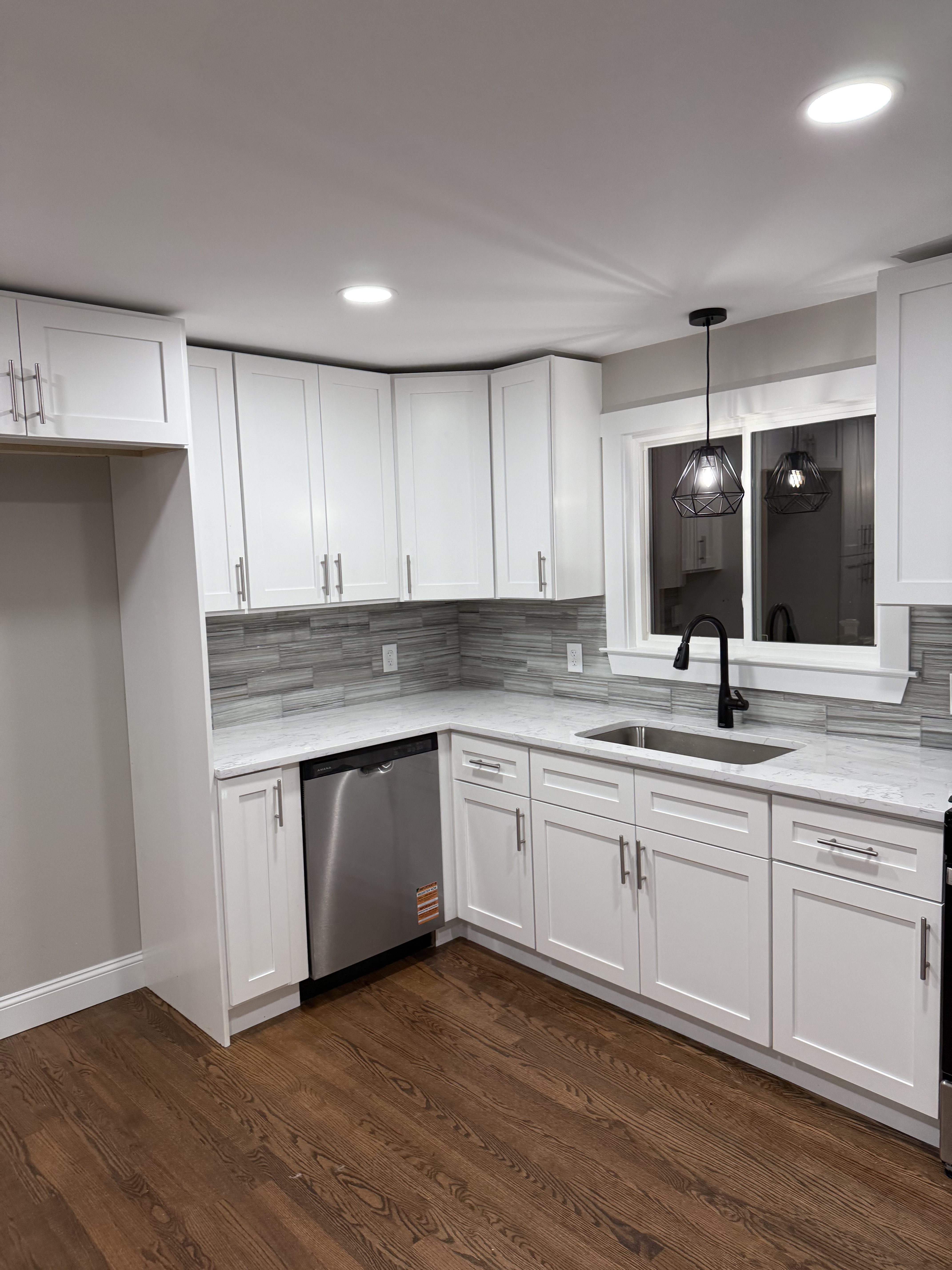 Light kitchen cabinetry with wood-look flooring